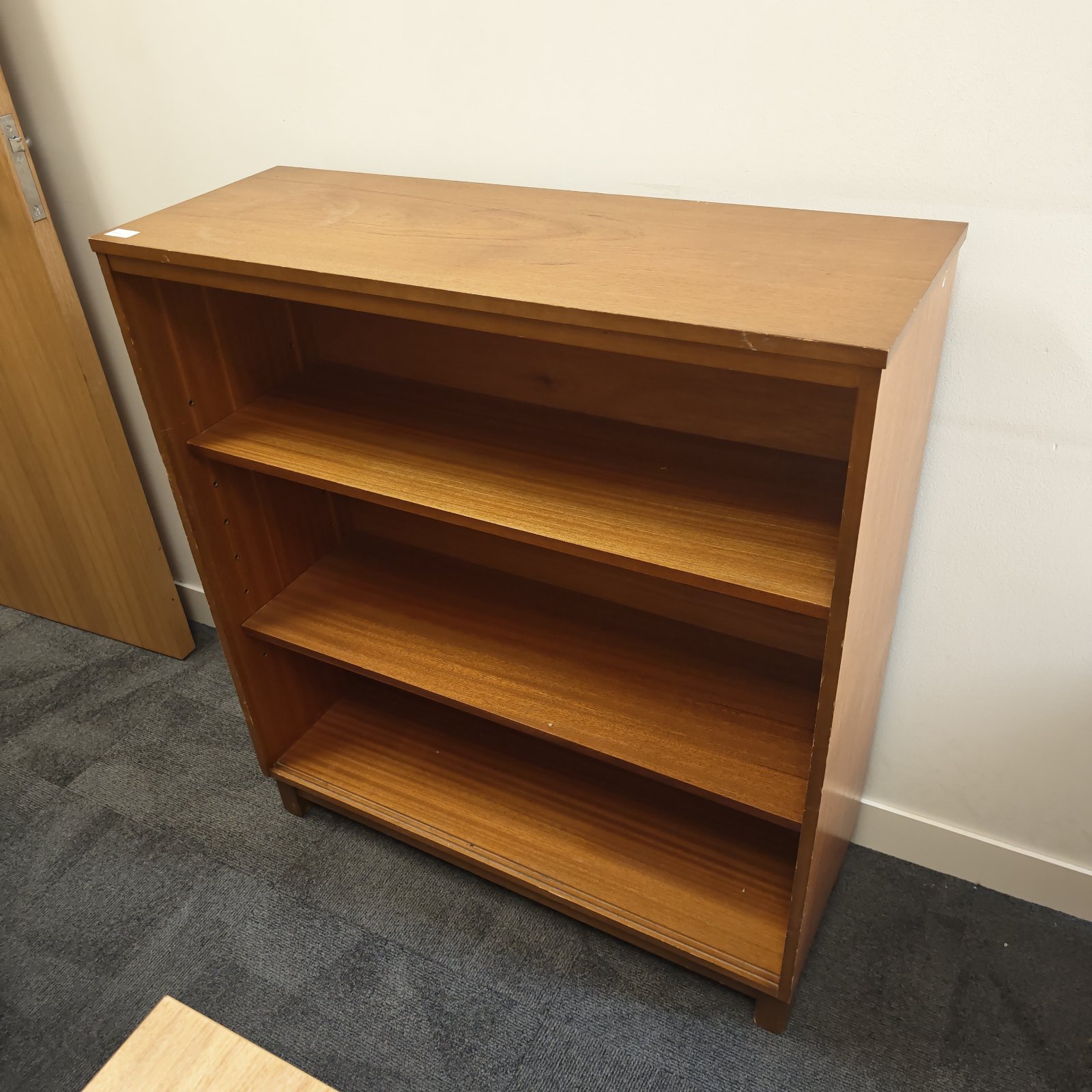 Vintage oak bookshelf with three shelves, ideal for home storage.