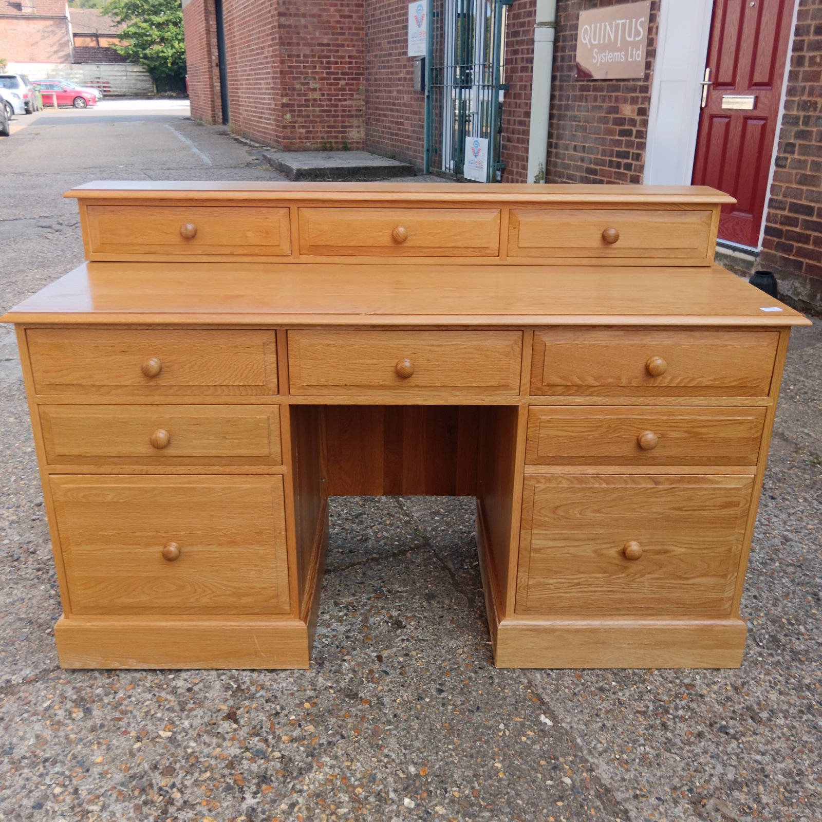 Classic oak pedestal desk with three drawers, ideal for office or home.
