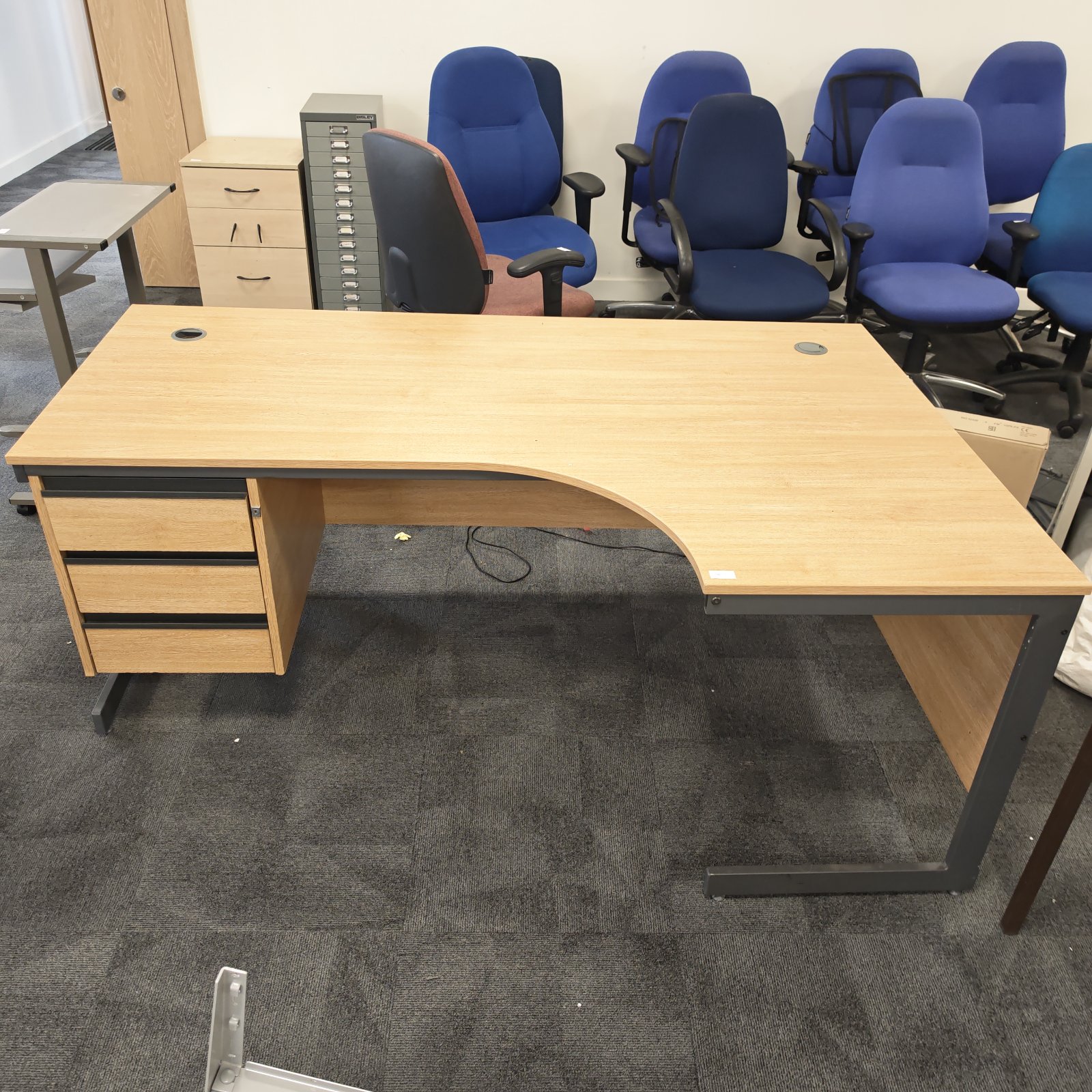 Wooden office corner desk with integrated drawers and black metal frame.