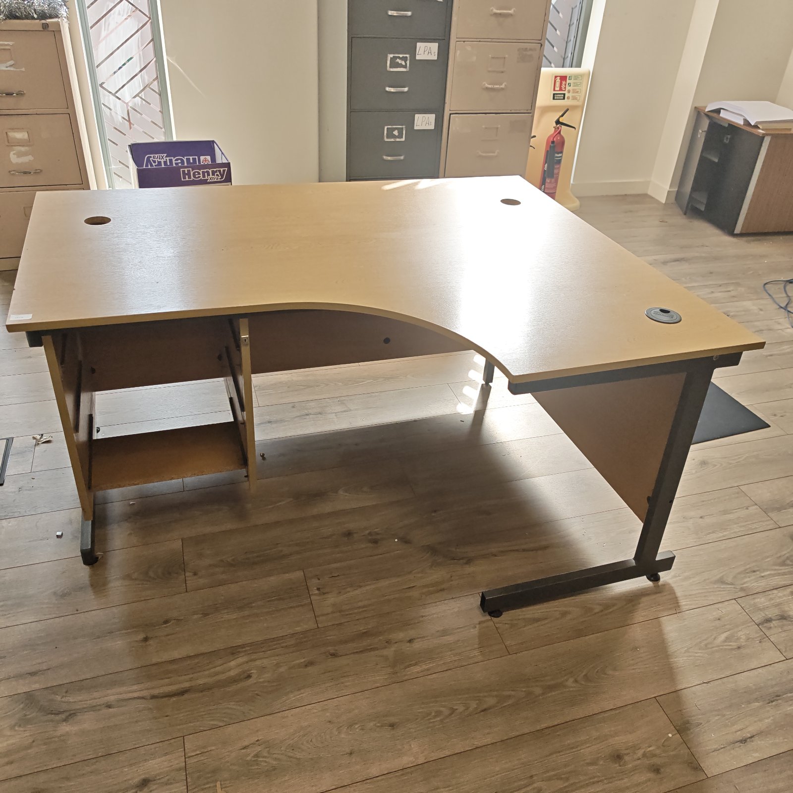 Light wood office desk with black legs, ideal for home office setup.