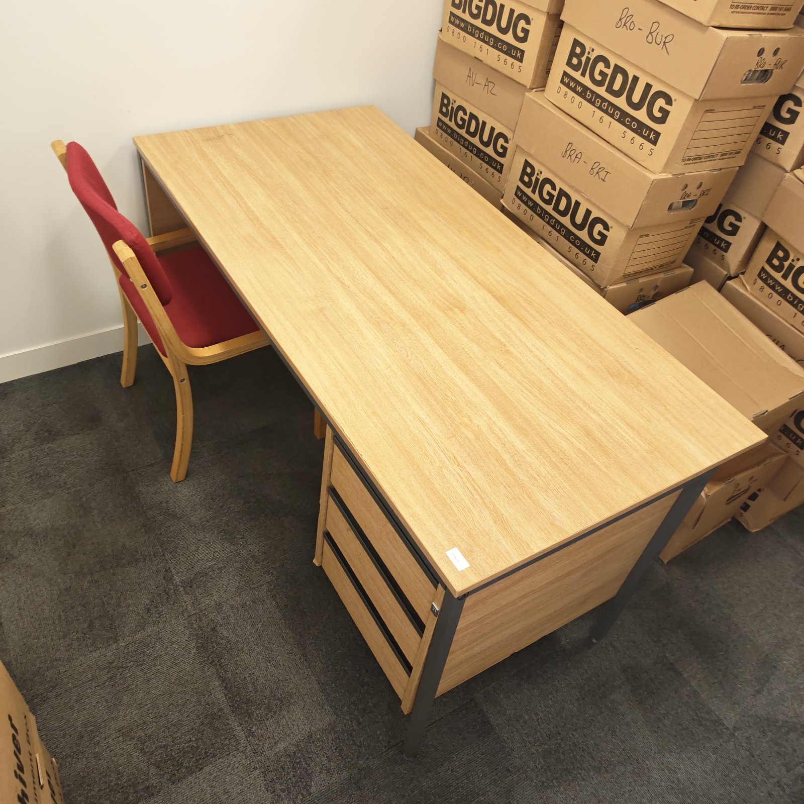 Vintage wooden office desk with three drawers and chair.