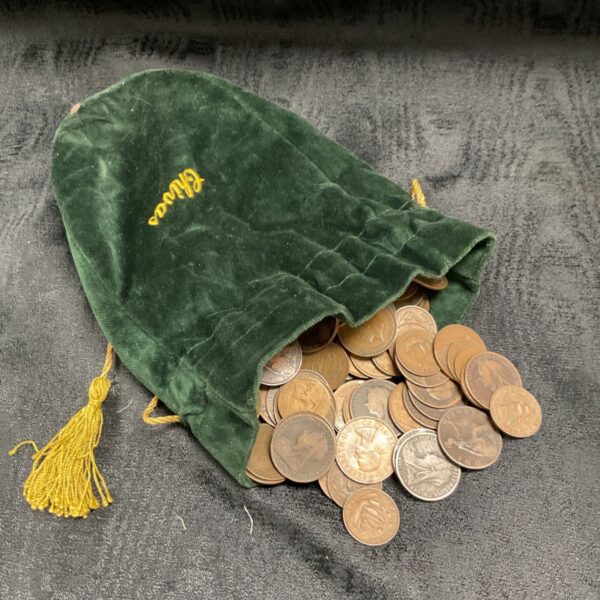 Emerald green velvet pouch filled with a large collection of old pennies.