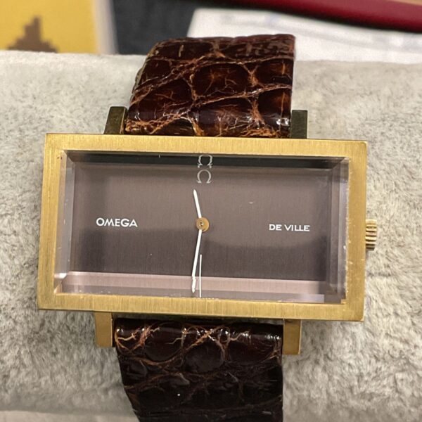 Vintage Omega De Ville wristwatch with gold case and leather strap.
