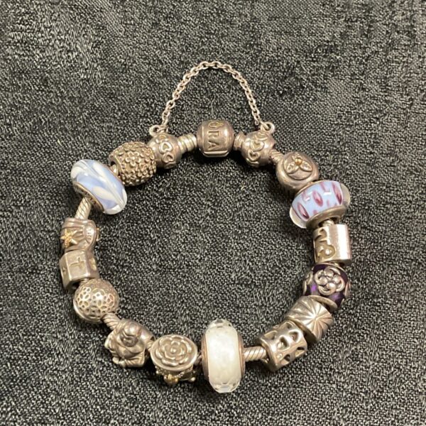 Silver Pandora charm bracelet with fourteen unique charms.