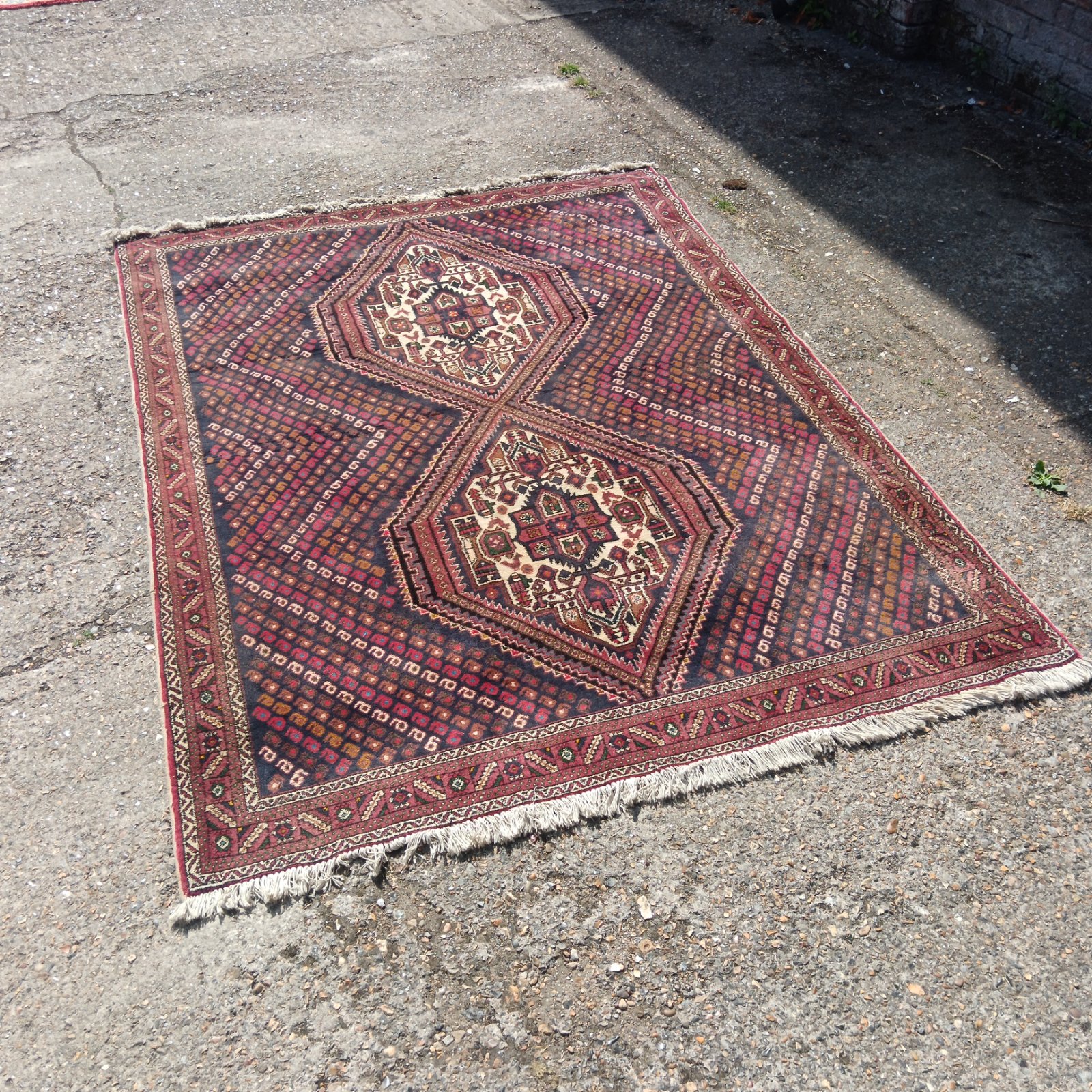 Detailed view of a vibrant Persian rug with geometric patterns.