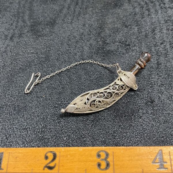 Antique Persian silver dagger brooch with intricate filigree details.