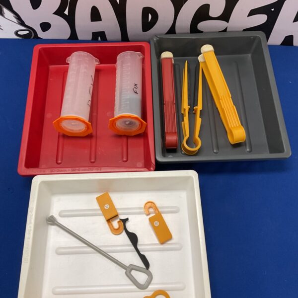 Photography developing trays and tongs for darkroom use.
