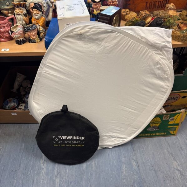 Portable photography lighting screen with light cube setup.