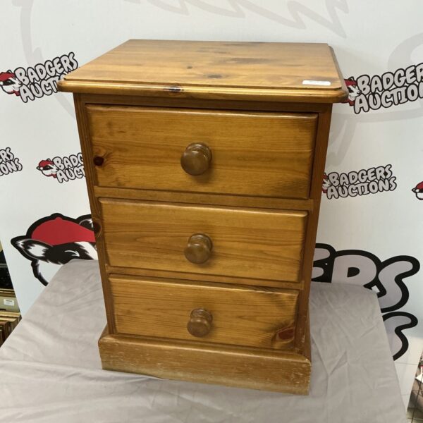 Vintage pine bedside table with three drawers, rustic bedroom furniture.