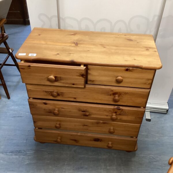 Vintage pine chest of drawers with four drawers and wooden knobs.