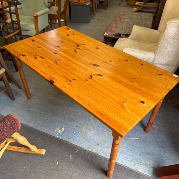 Large rustic pine dining table in a vintage setting.