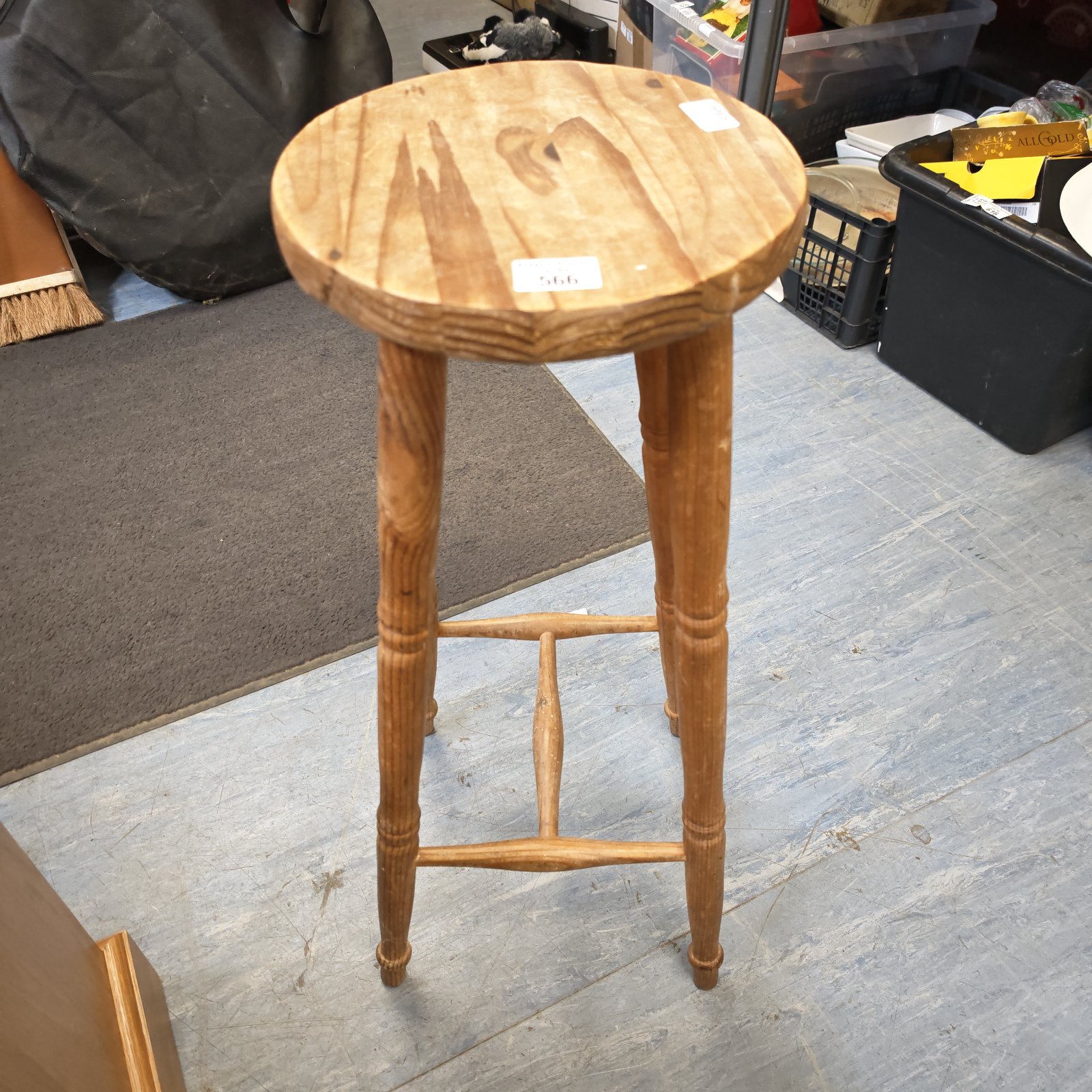 Rustic pine kitchen stool with a circular seat and three legs.