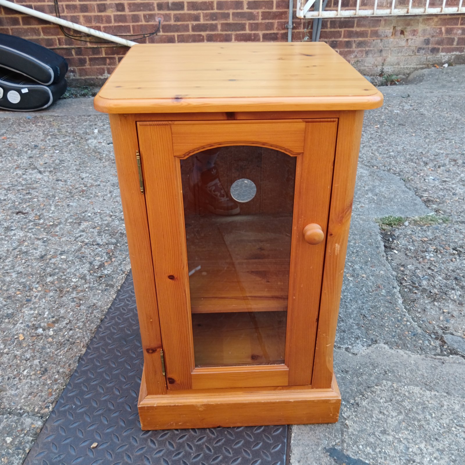 Vintage pine media cabinet with glass front for storage.