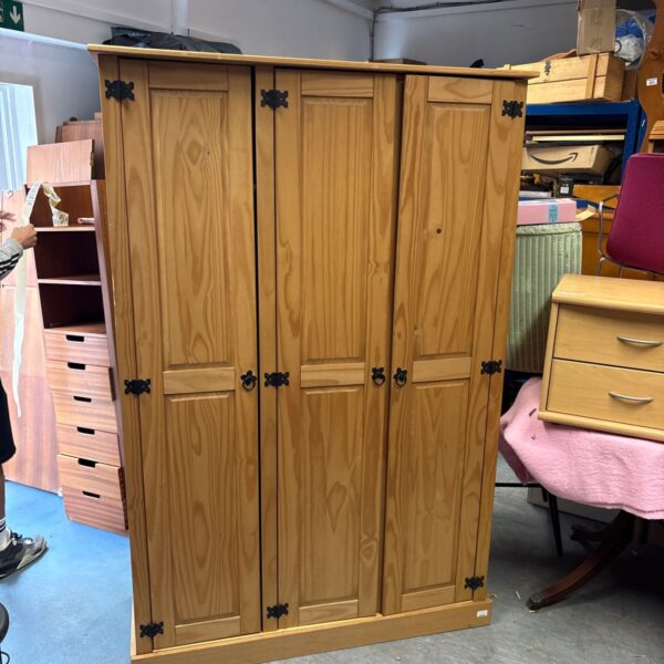 Vintage pine three-door wardrobe for bedroom storage.