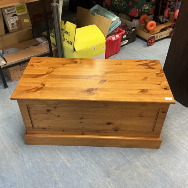 Front view of a rustic pine wood storage chest.