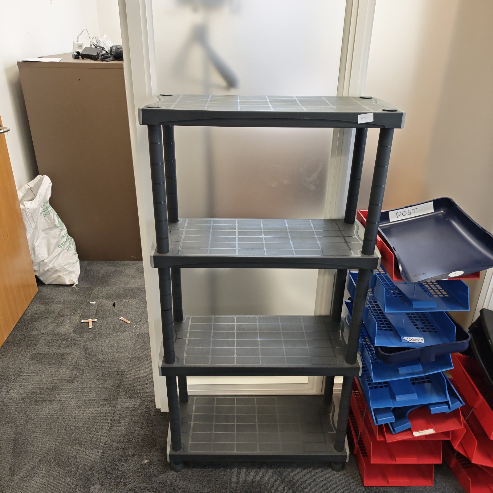 Four-tier plastic storage shelving unit with castors for easy mobility.