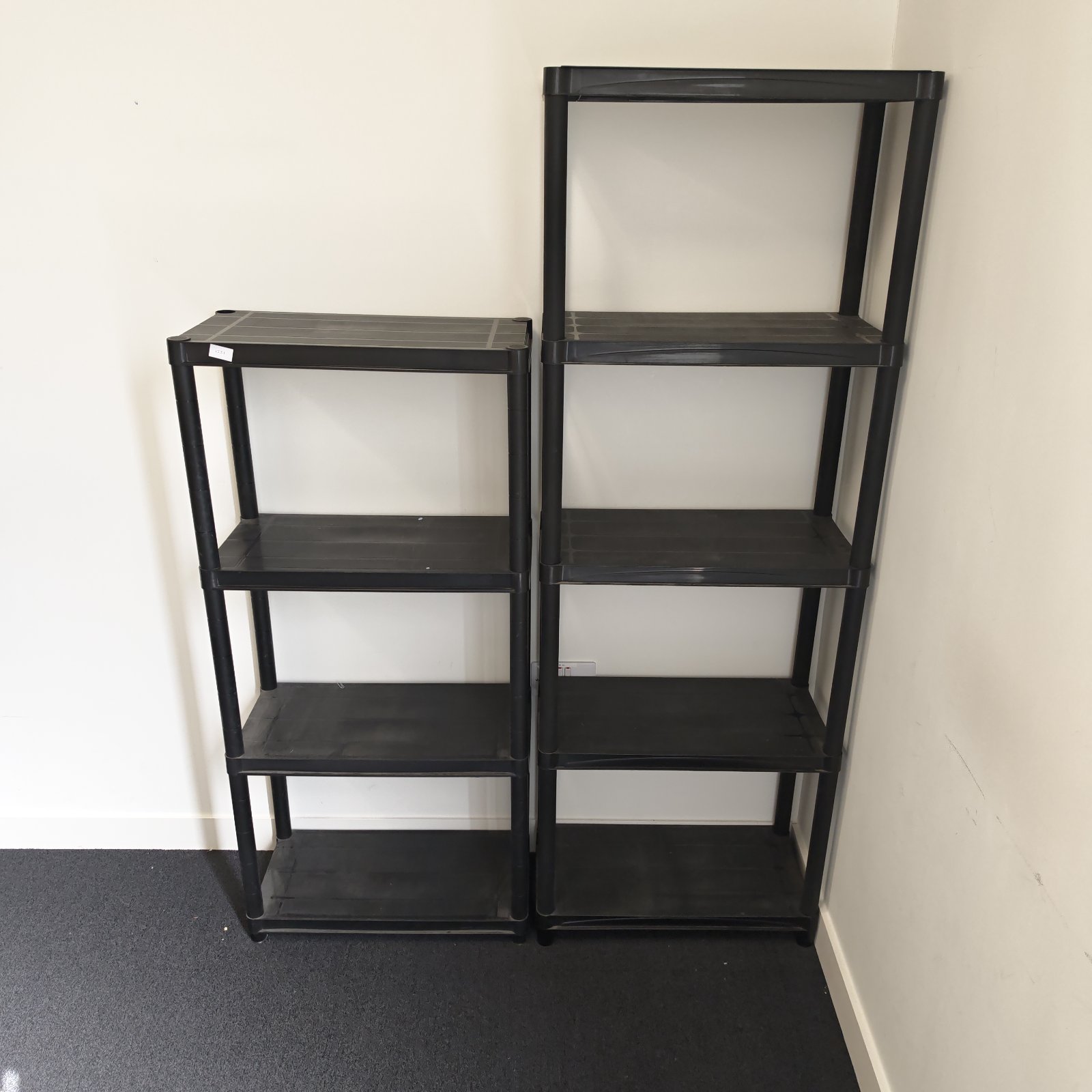 Two black plastic storage shelving units for home organisation.