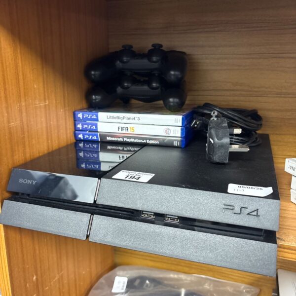 Sony PlayStation 4 console with games and controllers displayed.