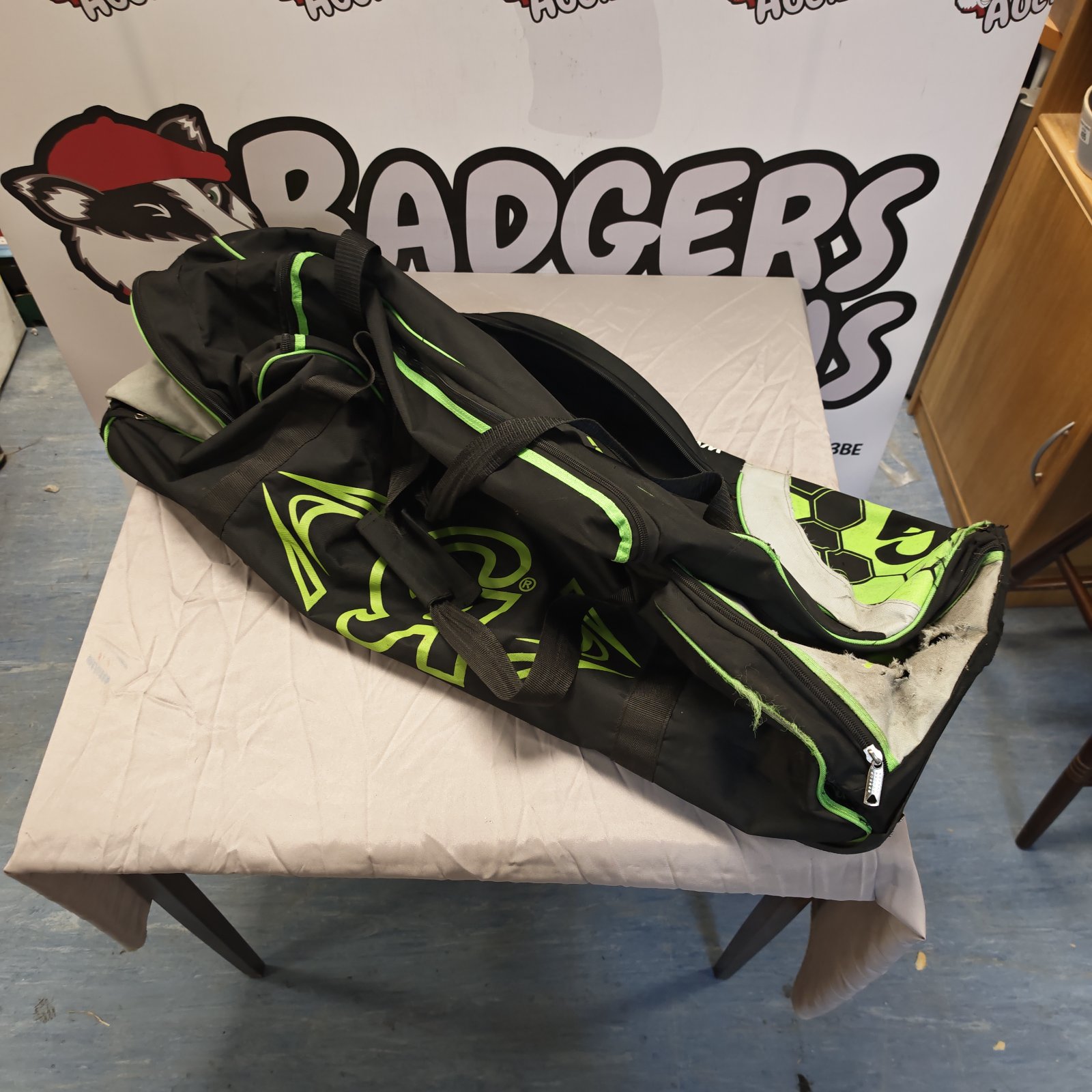 Black and green Plus 3000 cricket kit bag on a white surface.
