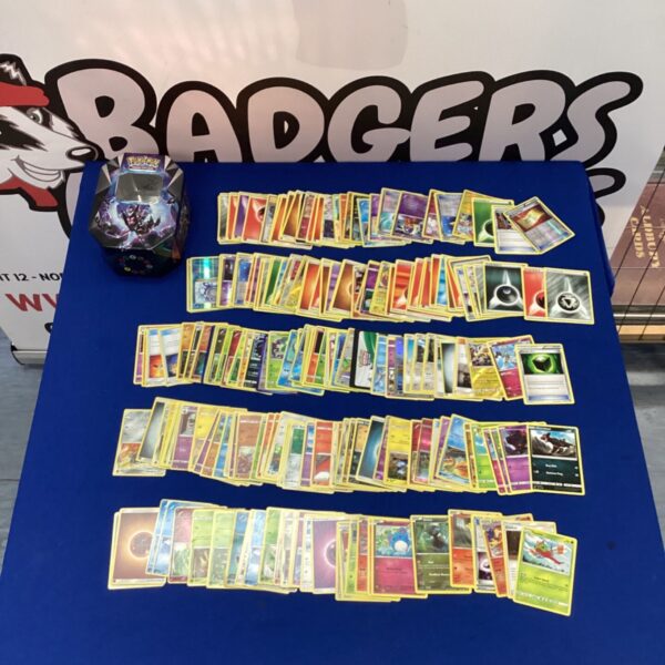 Assorted Pokemon cards inside a Pokemon collectors tin.