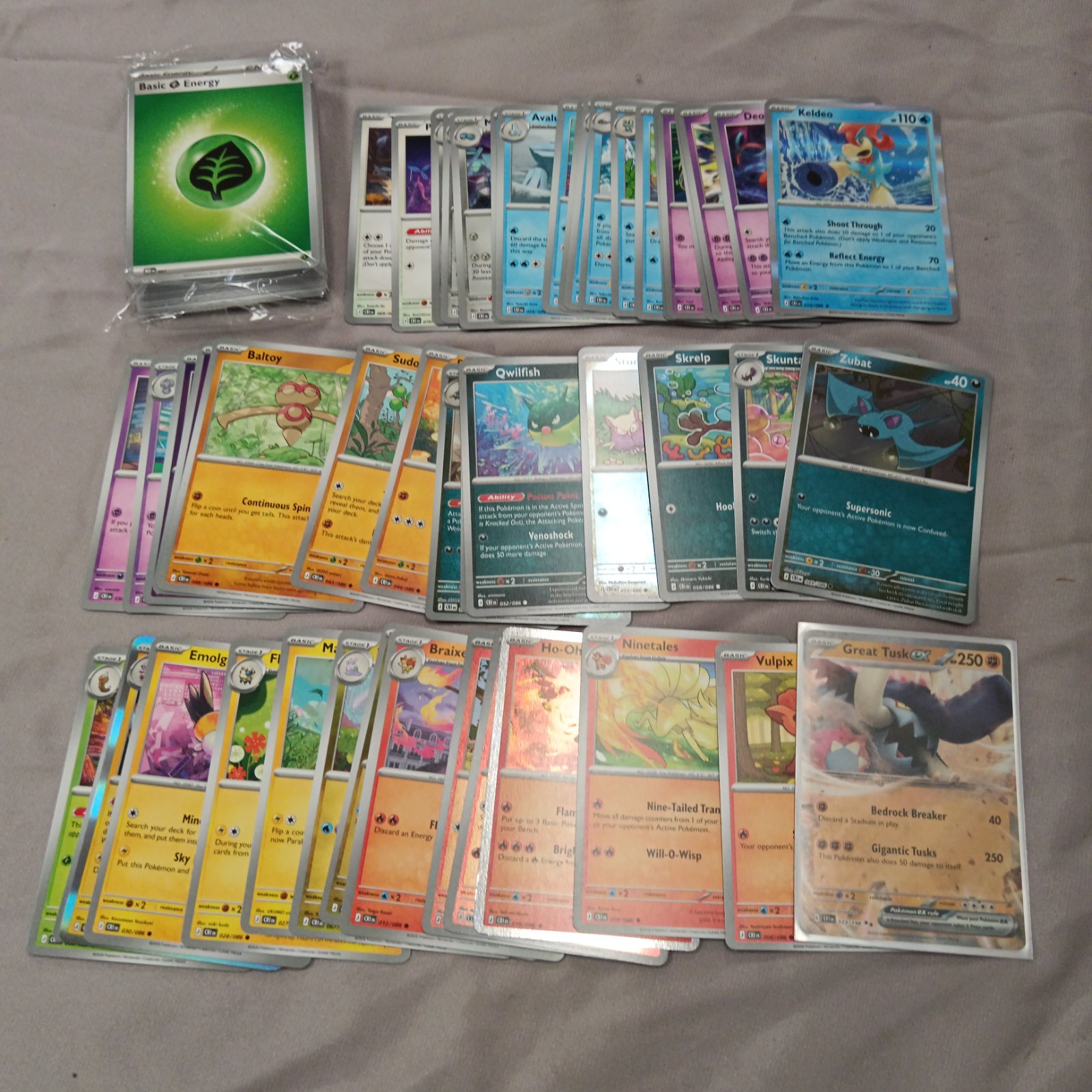 Pokémon cards lot featuring holographic cards and sealed energy pack.