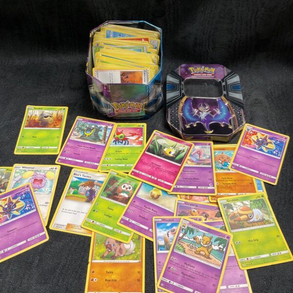 Assorted Pokemon cards in a tin, collectible trading card game.