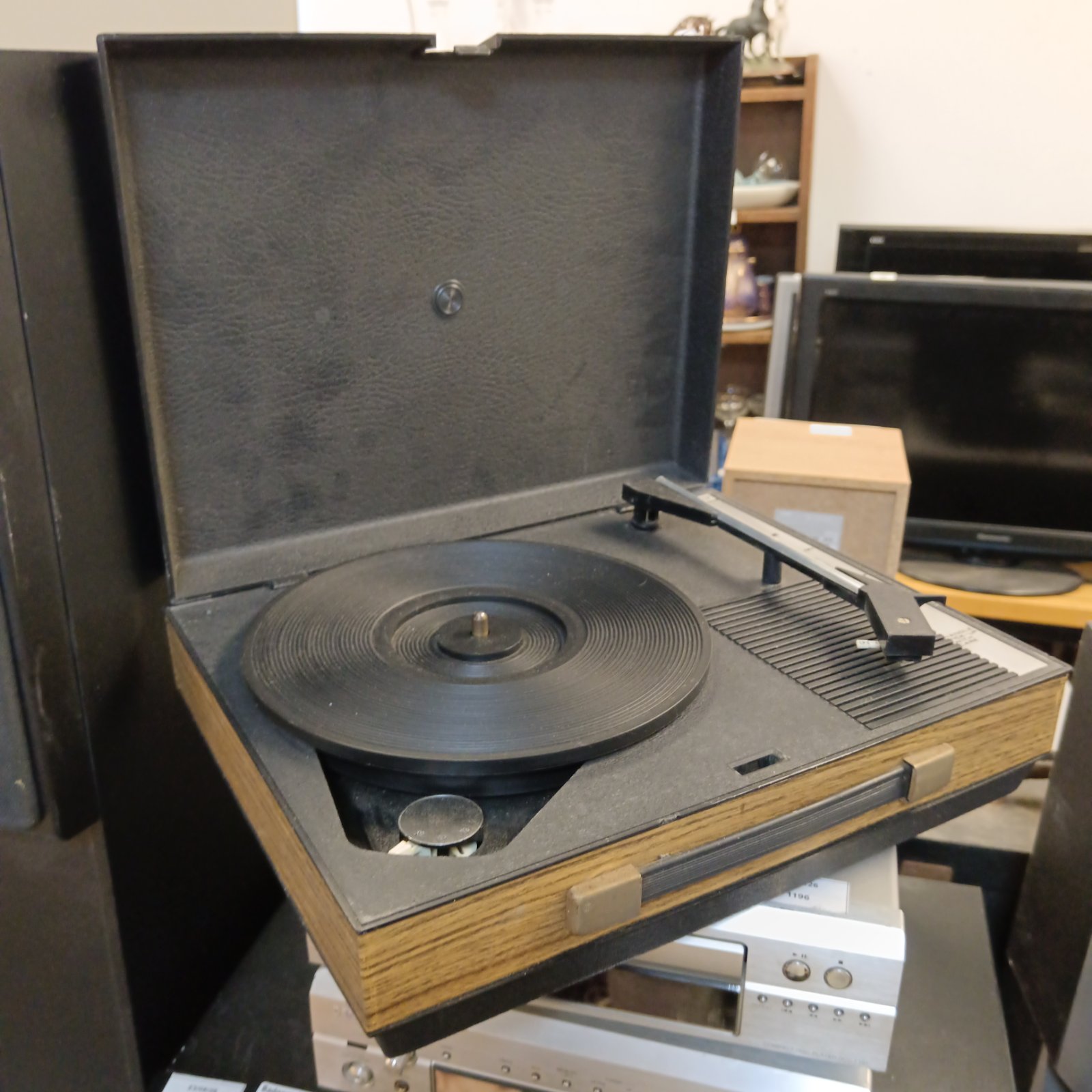 Vintage portable record player with turntable and wood case.