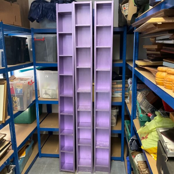 Three purple CD storage racks with media visible.