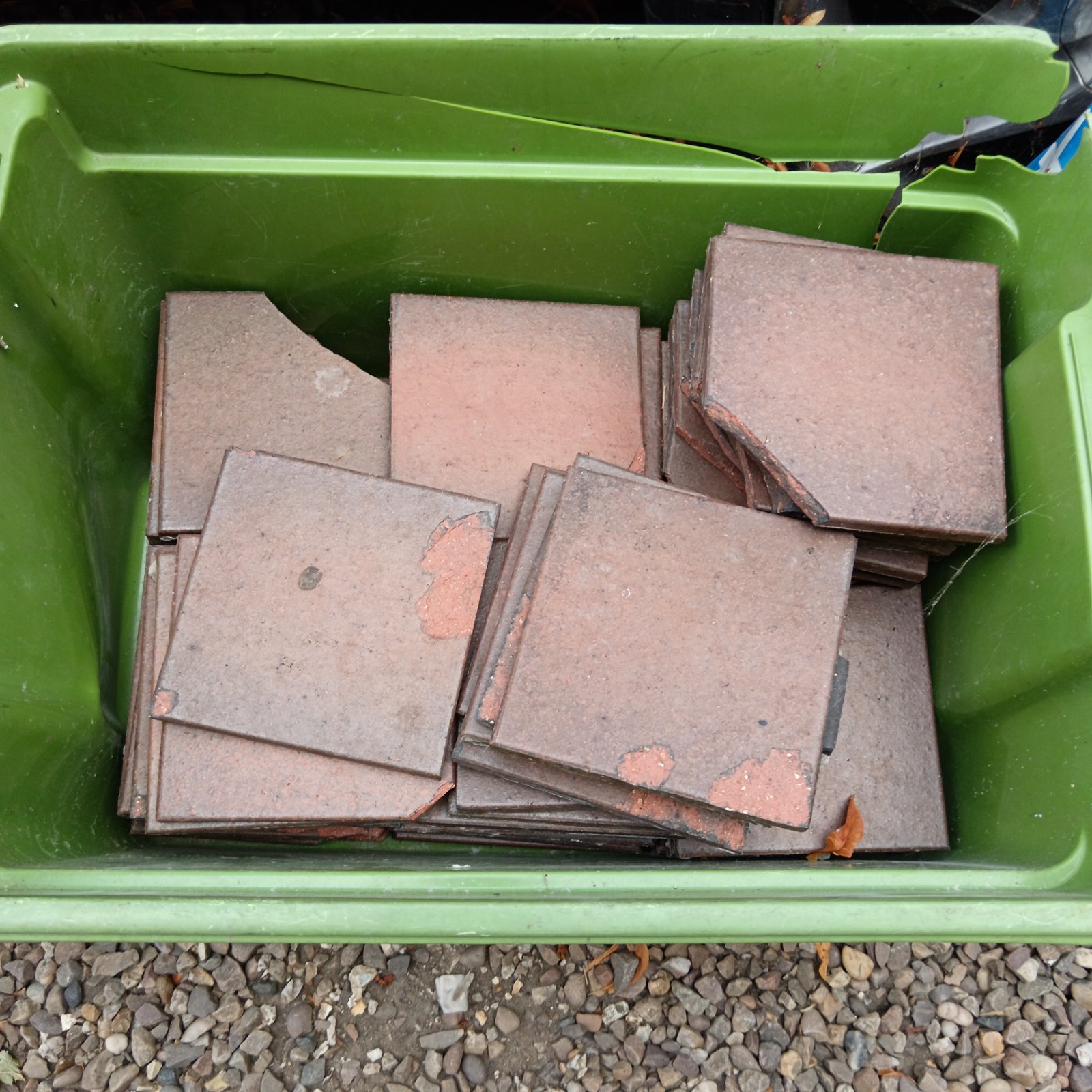 Box of chipped terracotta quarry tiles for restoration projects.