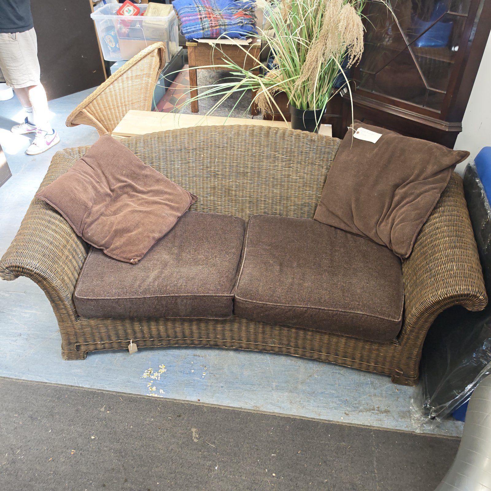 Brown Ralph Lauren rattan sofa with visible wear and tear.