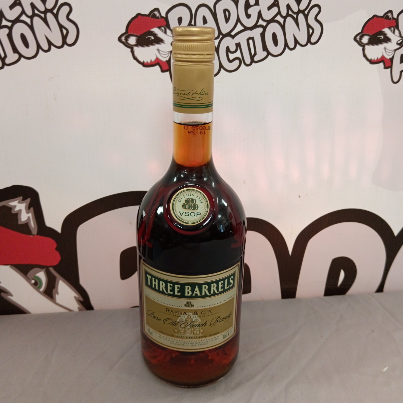 Vintage Raynal & Cie brandy bottle with "Three Barrels" label.