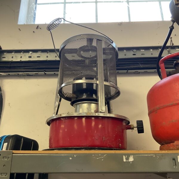 Vintage red chrome kerosene heater with wire guard.