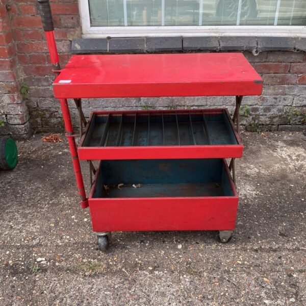 Vintage red mechanics service cart with sliding trays.
