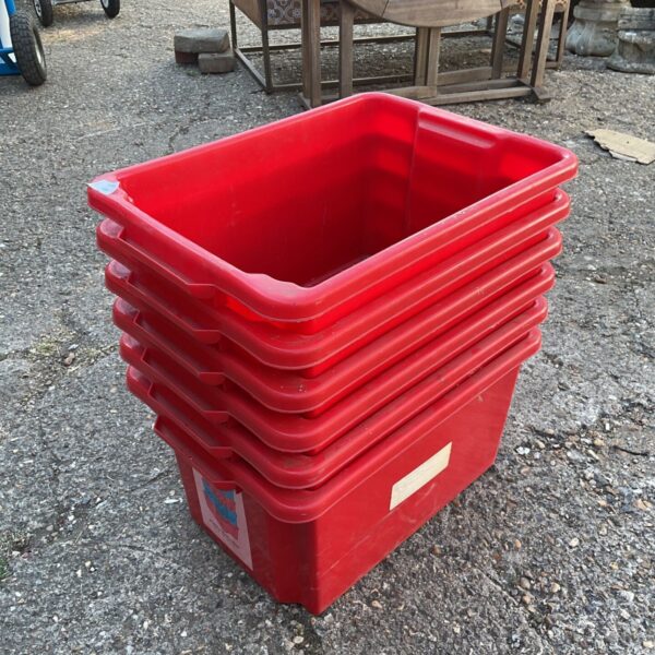 Six red stackable plastic boxes for storage and organisation.