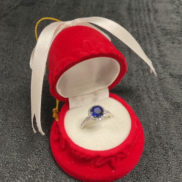 Red velvet bell displaying a silver CZ ring, Christmas ornament.