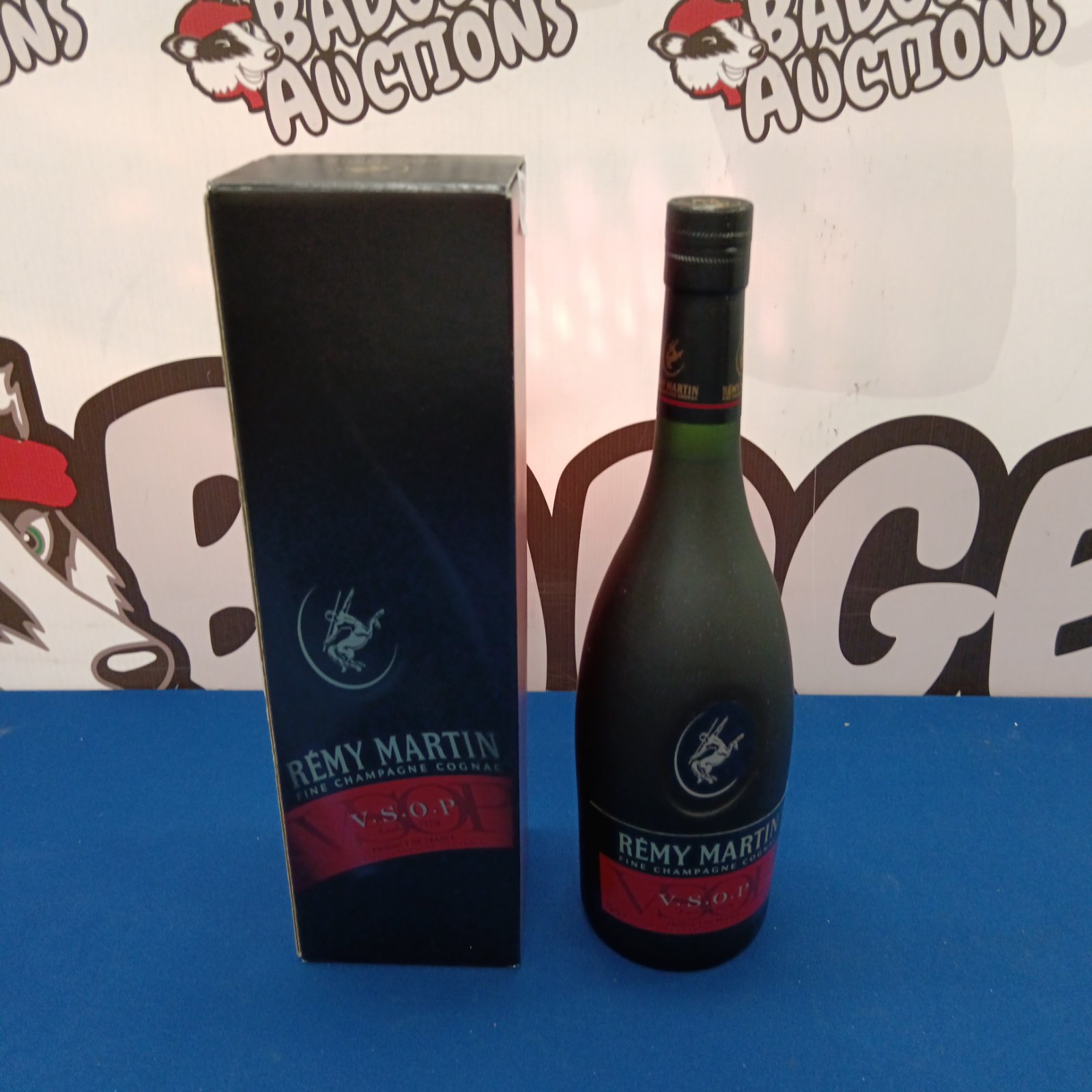 Sealed bottle of Remy Martin cognac in decorative tin.
