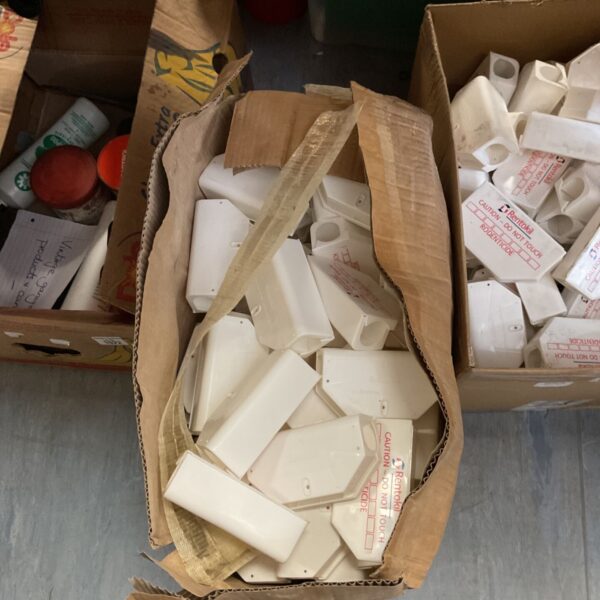 Box of used Rentokil rodenticide bait stations for pest control.