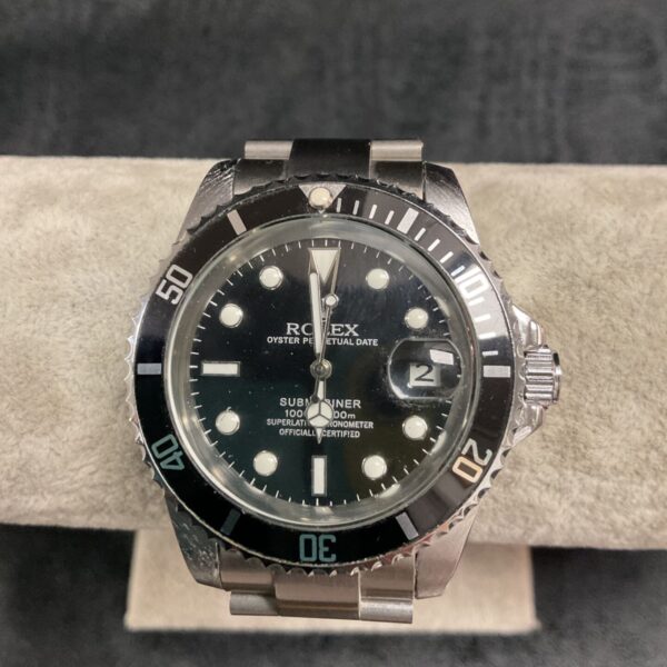 Replica Rolex Submariner watch with black dial and steel case.