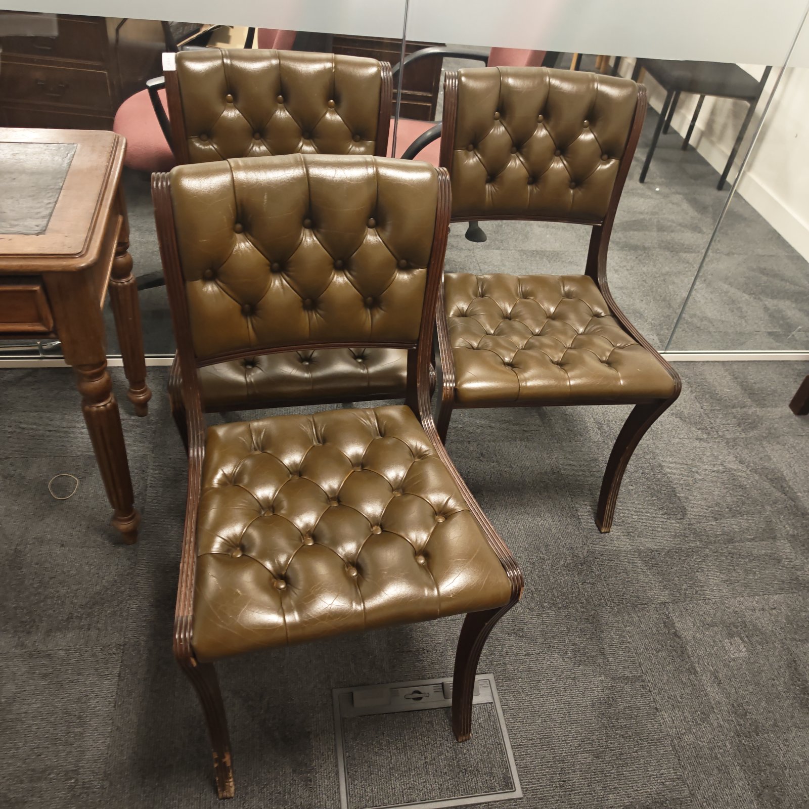 Set of three retro green leather reception chairs.
