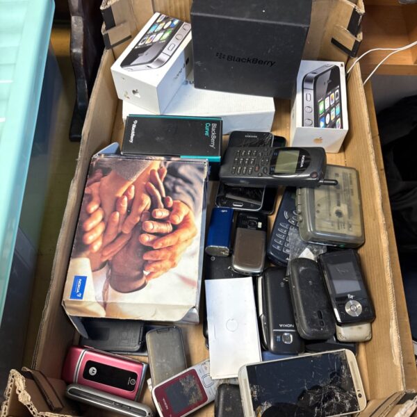 Box of vintage mobile phones including Apple and Nokia.