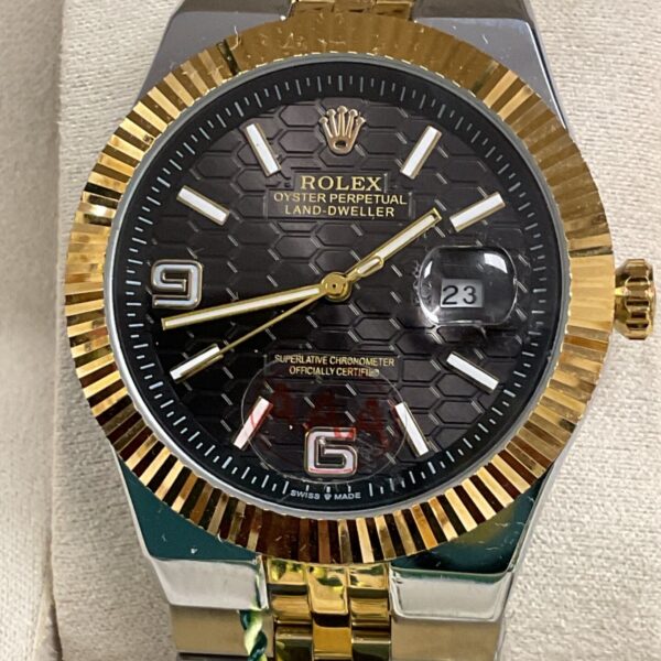 Close-up of Rolex style Land Dweller quartz wristwatch with gold accents.