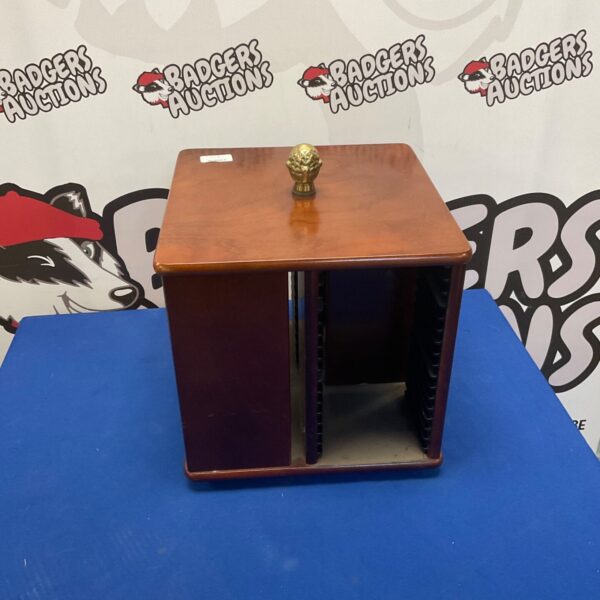 Vintage rotating CD rack with acorn finial for media storage.