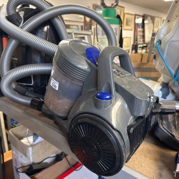 Grey Russell Hobbs Stowaway cylinder vacuum cleaner with hose attached.