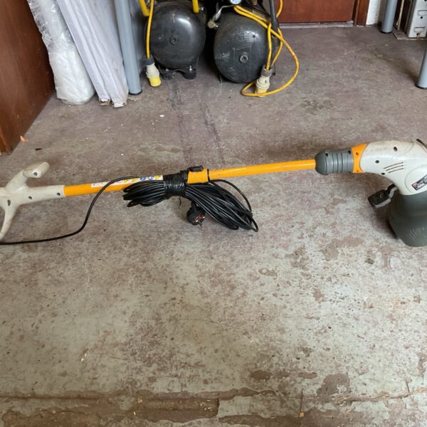 Ryobi electric grass trimmer for garden maintenance and lawn care.