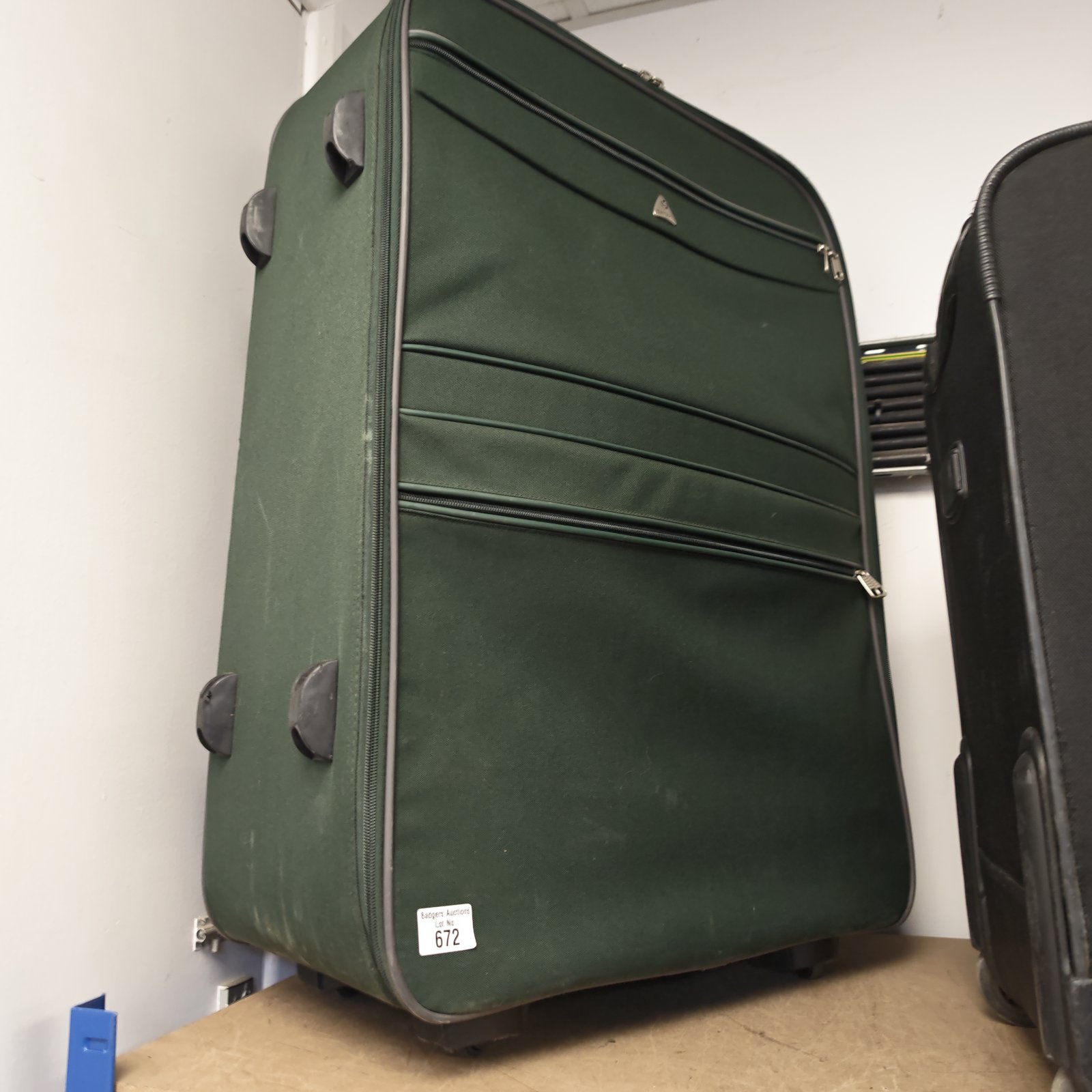 Large green Samsonite wheeled suitcase with extending handle.