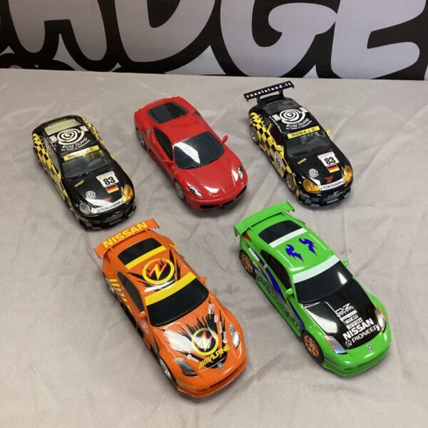 Scalextric cars lot featuring Ferrari, Porsche, and Nissan racing models.