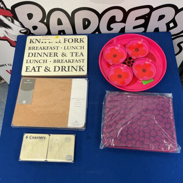 Vintage pink serving trays and colourful placemats in a collectible lot.