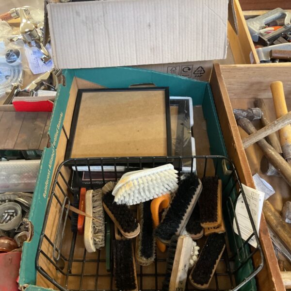 Vintage shoe shining kit with brushes and picture frames in a box.