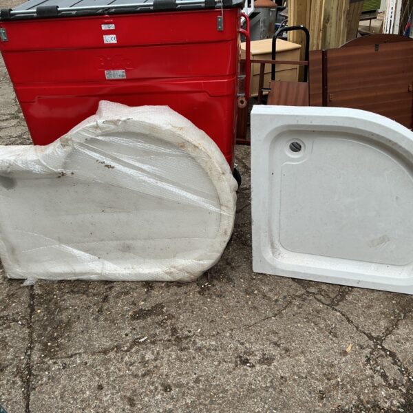 Pair of used shower trays, one ceramic and one fibreglass.