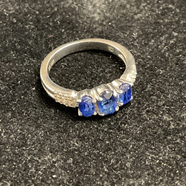 Silver ring with three blue stones, size J.